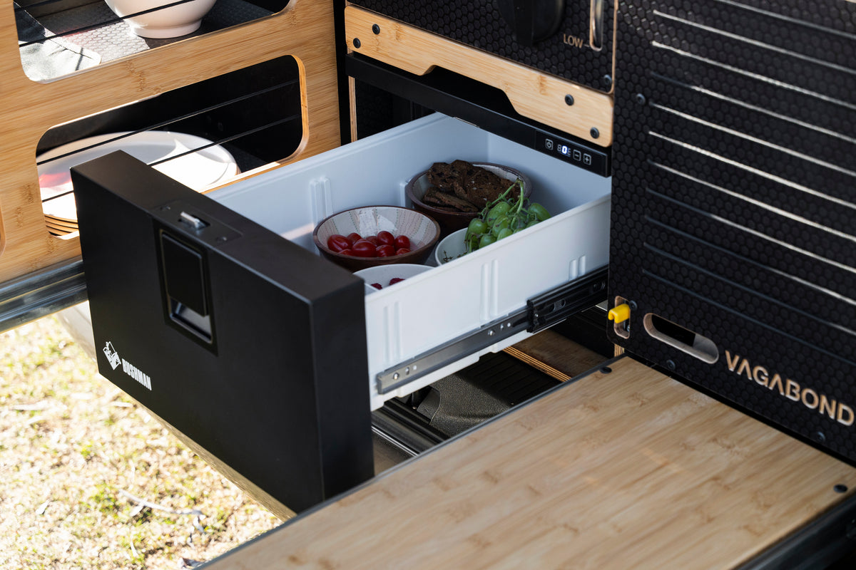 Showcasing a chest fridge in vagabond camping conversion kit with slide out seating outdoor area. 
