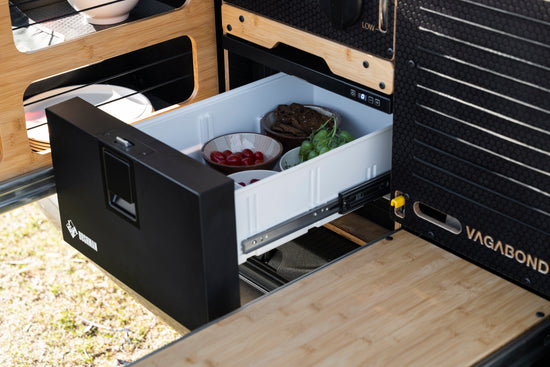 Showcasing a chest fridge in vagabond camping conversion kit with slide out seating outdoor area. 