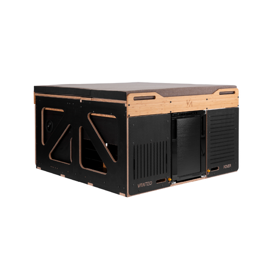 A black and wooden Vanted Rover Pod with kitchen facilities and storage space, designed for vehicle mounting.